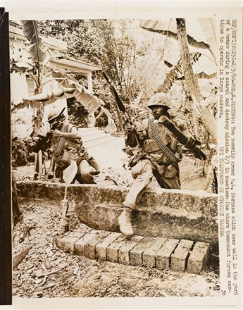 (VIETNAM WAR) A group of approximately 67 press photographs on the ground in Vietnam.